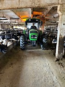 Трактор Deutz Fahr Agrolux 4.80 на раздаче кормов на ферме с низким потолком 
